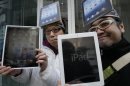 Japanese Ryota Musha, 41, right, and Hisanori Kogure, 31, show off new iPad tablet computers they purchased, in Tokyo Friday, March 16, 2012. Sales of the third version of Apple's iPad began Friday morning in Japan. (AP Photo/Koji Sasahara)