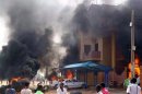 Cars burn in front of a building during protests over fuel subsidy cuts in Khartoum