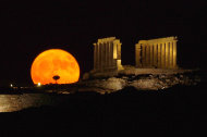 FILE - In this Thursday, July 21, 2005 file photo, the full moon rises behind the ancient temple of Posseidon, in Sounio about 73 kilometers (45 miles) southeast of Athens. That old moon might not be as antique as we thought, some scientists think. They say it's possible that it isn't a day over 4.4 billion years old. But other astronomers disagree with a new study's conclusions. They think the moon is up to its typical age-defying tricks and is really pushing 4.6 billion as they have suspected all these years. Either way, the new analysis of an important moon rock brought back by the Apollo 16 mission is showing that the moon isn't ready to give up its true age and origins quite yet, even though scientists thought they had it all figured out a decade or two ago. (AP Photo/Petros Giannakouris)