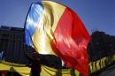 Man waves Romanian national flag during a march in downtown Bucharest