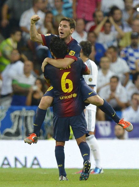 Barcelona's Lionel Messi (top) celebrates his goal against Real Madrid with team mate Xavi Hernandez during their Spanish Super Cup second leg soccer match at Santiago Bernabeu stadium in Madrid