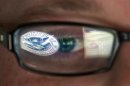 FILE - This Sept. 30, 2011 file photo shows a reflection of the Department of Homeland Security logo in the eyeglasses of a cybersecurity analyst at the watch and warning center of the Department of Homeland Security's secretive cyber defense facility in Idaho Falls, Idaho. The center is tasked with protecting the nation's power, water and chemical plants, electrical grid and other facilities from cyber attacks. (AP Photo/Mark J. Terrill, File)