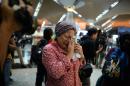 A woman reacts to news regarding a Malaysia Airlines plane that crashed in eastern Ukraine at Kuala Lumpur International Airport in Sepang, Malaysia, Friday, July 18, 2014. Ukraine said a passenger plane carrying 295 people was shot down Thursday as it flew over the country, and both the government and the pro-Russia separatists fighting in the region denied any responsibility for downing the plane. (AP Photo/Joshua Paul)