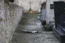 A crucifix is left lying on the ground next to graves at a cemetery in Tracy-sur-Mer, on the coast of Normandy on February 18, 2015