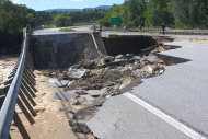 People take photos of a washed-out section of Route 7 south of Rutland, Vt., Monday, Aug. 29, 2011, following heavy rains from Tropical Storm Irene that swelled rivers the day before. (AP Photo/The Rutland Herald, Vyto Starinskas) MANDATORY CREDIT