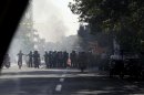 This photo, taken by an individual not employed by the Associated Press and obtained by the AP outside Iran shows Iranian police officers blocking a street as garbage cans are set on fire, in central Tehran, near Tehran's old main bazaar, on Wednesday, Oct. 3, 2012. Police threatened merchants who closed their shops in Tehran's main bazaar and launched crackdowns on sidewalk money changers on Wednesday as part of a push to halt the plunge of Iran's currency, which has shed more than a third its value in less than a week. (AP Photo) EDITORS NOTE AS A RESULT OF AN OFFICIAL IRANIAN GOVERNMENT BAN ON FOREIGN MEDIA COVERING SOME EVENTS IN IRAN, THE AP WAS PREVENTED FROM INDEPENDENT ACCESS TO THIS EVENT.