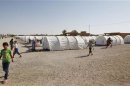 Syrian refugees walk at a refugee camp in al-Qaim, Anbar province