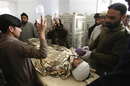 An anti-polio drive campaign worker, Hilal Khan (C), who was shot and badly injured by unidentified gunmen, lies at Lady Reading Hospital in Peshawar December 19, 2012. REUTERS/Khuram Parvez