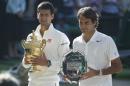 Novak Djokovic of Serbia, left, holds the trophy after defeating Roger Federer of Switzerland in the men's singles final at the All England Lawn Tennis Championships in Wimbledon, London, Sunday July 6, 2014. (AP Photo/Pavel Golovkin)