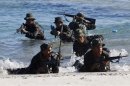 Philippine Military Academy (PMA) cadets take up positions for assault on a beach during a joint field training exercise at the Marines' training centre in Ternate, south of Manila