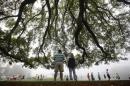 Golf patrons wander the foggy grounds during player practice rounds ahead of the 2015 Masters at Augusta National Golf Course in Augusta
