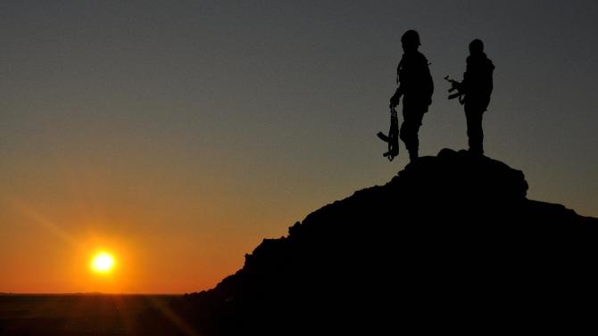 People&#39;s Protection Units (YPG) fighters stand on a hill at sunset on February 26, 2015, after they retook parts of the town of Tal Hamis, southeast of the city of Qameshli, after six days of clashes with Islamic State (IS) group jihadists