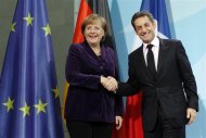 French President Nicolas Sarkozy and German Chancellor Angela Merkel shake hands after a news conference following their talks at the Chancellery in Berlin January 9, 2012.  REUTERS/Fabrizio Bensch