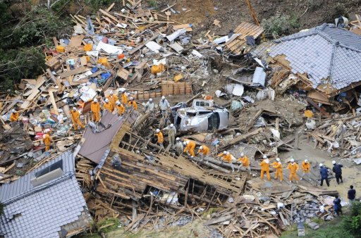 An aerial view shows firefighters searching among collapsed houses following a landslide caused by strong tropical storm Talas in Tanabe, in western Japan