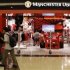 Shoppers walk past a Manchester United merchandise store at a mall in Singapore