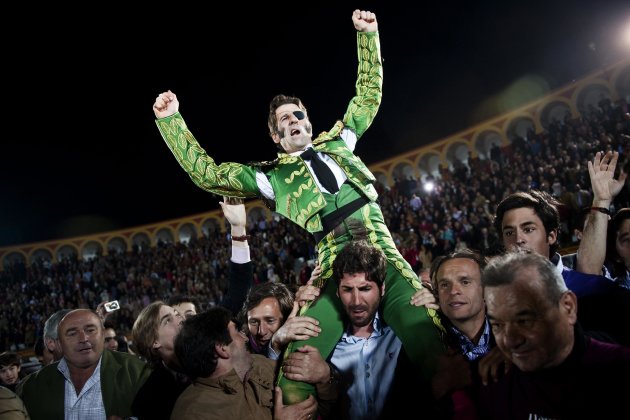 Spanish bullfighter Juan Jose Padilla is carried out of the ring among jubilant crowd scenes on the shoulders of fellow bullfighter Serafin Marin, a honor for the best performers, after a bullfight at the southwestern Spanish town of Olivenza, Sunday, March 4, 2012. Padilla, 38-year-old matador who is also known by his professional name of 'the Cyclone of Jerez', lost sight in one eye and has partial facial paralysis after a terrifying goring returned to the bullring Sunday, five months after his injury.(AP Photo/Daniel Ochoa de Olza)
