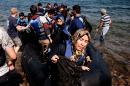 Refugees and migrants arrive on Eftalou beach, west of the port of Mytilene, on the Greek island of Lesbos after crossing the Aegean sea from Turkey on September 21, 2015