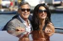 George Clooney, left, and Amal Alamuddin arrive in Venice, Italy, Friday, Sept. 26, 2014. Clooney, 53, and Alamuddin, 36, are expected to get married this weekend in Venice, one of the world's most romantic settings. (AP Photo/Luca Bruno)