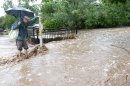 Matthew Messner looks for a way to cross where water has over flowed the sidewalk from heavy rains in Boulder Colorado