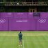 A workman takes a photograph on Court 10 as Olympic hoarding is erected at the All England Lawn Tennis Club as preparations are made for the London 2012 Olympic Games, in London
