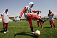 Players of Iran's women national football team warm-up in 2009. Football chiefs agreed on Thursday to lift a ban on women wearing headscarves during games, clearing the way for the participation of many Muslim nations in top-flight competition