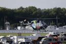 A helicopter lifts off at Pocono Raceway carrying race car driver Justin Wilson, of England, after he was involved in a crash during the Pocono IndyCar 500 auto race Sunday, Aug. 23, 2015, in Long Pond, Pa. (AP Photo/Mel Evans)
