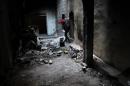 An opposition fighter patrols through an abandoned building in the Jubaila neighbourhood of Syria's northeastern city of Deir Ezzor on October 22, 2013