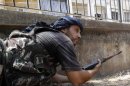 A Free Syrian Army fighter takes up position during clashes in Aleppo