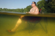 William Dyer, Jr., of Gortham, Maine stays cool seated on his beach chair waist-deep in Sabbathday Lake in New Gloucester, Maine, Thursday, July 21, 2011. The heat that has gripped much of the nation arrived in Maine on Friday. (AP Photo/Robert F. Bukaty)