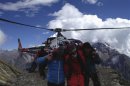 Rescue team members carry a tourist after an avalanche at Mount Manaslu Base Camp