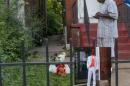 The father of Mansur Ball-Bey stands in front of the steps where police shot his son as a photo of Mansur hangs on the fence in St. Louis
