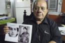 Raul Borges holds a picture of his son in his house in Havana