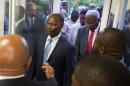 Interim President Jocelerme Privert, center, arrives with the president of the special verification commission Francois Benoit, to the national palace, in Port-au-Prince, Haiti, Monday, May 30, 2016. The special verification commission recommended throwing out the disputed results of last year's first-round presidential election because it appeared to be tainted by fraud. (AP Photo/Dieu Nalio Chery)