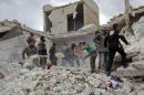 Rescuers and civilians inspect a destroyed building in the Syrian village of Kfar Jales, on the outskirts of Idlib, following air strikes by Syrian and Russian warplanes on November 16, 2016