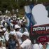 Israeli medical staff demonstrate in front of the Knesset, Israel's parliament, background in Jerusalem, Sunday, July 31, 2011. Hundreds of Israel's doctors are demonstrating in Jerusalem, stepping up their protest for higher wages and better hospital conditions. The banner in the picture carries a cutout of Israeli Prime Minister Benjamin Netanyahu reads in Hebrew: " Where did you disappear, Netanyahu ? " . (AP Photo/Sebastian Scheiner)