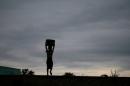 Storm clouds loom as a child carries water from a communal borehole near Malawi's capital Lilongw