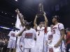 Louisville guard Peyton Siva (3) holds up the regional trophy as Louisville players celebrate their 85-63 win over Duke in  the Midwest Regional final in the NCAA college basketball tournament, Sunday, March 31, 2013, in Indianapolis. (AP Photo/Michael Conroy)