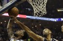 El escolta de los Grizzlies de Memphis Tony Allen (9) intenta encestar pero el delantero de los Spurs de San Antonio Tim Duncan (21) alcanza la pelota durante la primera mitad del tercer partido de la final de la Conferencia del Oeste de la NBA, el sábado 25 de mayo de 2013, en Memphis, Tenesí. (Foto AP/Danny Johnson)