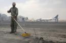 A man clears debris from the tarmac of Jinnah International Airport, after Sunday's attack by Taliban militants on Sunday, in Karachi