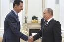 Russian President Putin shakes hands with Syrian President Assad during a meeting at the Kremlin in Moscow