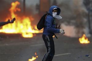An anti-government protester turns after throwing a molotov at police during clashes in Caracas