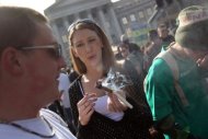 A jovem passa um cigarro de maconha durante 'marcha da maconha' em Denver, Colorado, abril de 2010