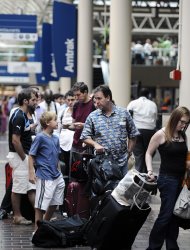 Travelers wait in line to board Amtrak's Northeast Regional train to Boston at Union Station in Washington, Friday, Aug. 26, 2011. (AP Photo/Cliff Owen)