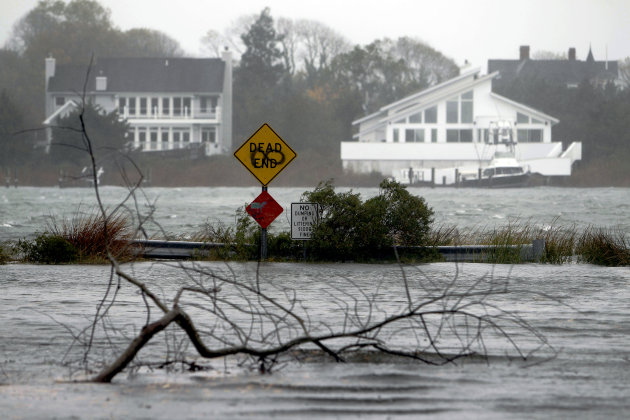 A downed limb lies in a flooded street as Hurricane Sandy approaches, Monday, Oct. 29, 2012, in Center Moriches, N.Y. Hurricane Sandy continued on its path Monday, as the storm forced the shutdown of mass transit, schools and financial markets, sending coastal residents fleeing, and threatening a dangerous mix of high winds and soaking rain.  (AP Photo/Jason DeCrow)