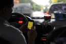 A taxi driver checks an app on his smartphone in Rio de Janeiro