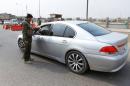 A policeman checks a driver's identification at a checkpoint in Kirkuk