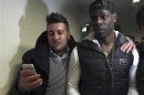 A fan flanks soccer player Mario Balotelli of Italy as Balotelli arrives at the AC Milan medical centre in Busto Arsizio near Milan