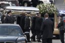 The coffin holding the remains of singer Whitney Houston is carried to a hearse after funeral services at the New Hope Baptist Church in Newark, N.J., Saturday, Feb. 18, 2012. Houston died last Saturday at the Beverly Hills Hilton in Beverly Hills, Calif., at the age 48. (AP Photo/Mel Evans)