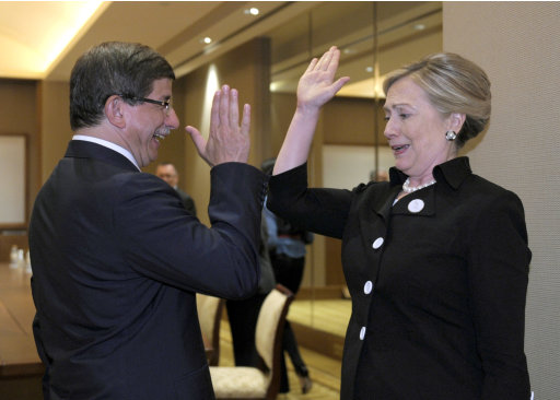 Secretary of State Hillary Rodham Clinton gives Turkey's Foreign Minister Ahmet Davutoglu a high five at the start of their bilateral meeting at the Emirates Palace Hotel in Abu Dhabi, United Arab Emirates, Thursday, June 9, 2011. (AP Photo/Susan Walsh, Pool)