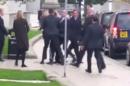 A still image taken from video shows Britain's Prime Minister David Cameron watching as his close protection team detain a man who approached him leaving a news conference in Leeds